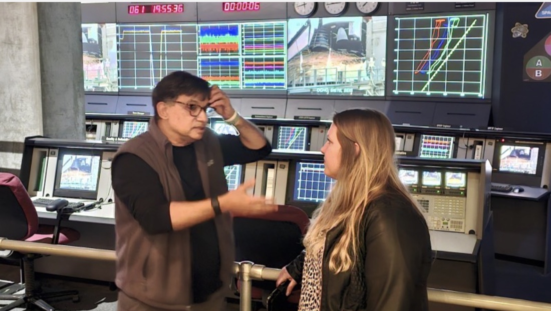 Gesprek in een controlekamer voor procesbewaking, met live meetschermen op de achtergrond